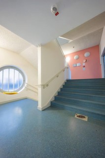 Interior with blue staircase, modern design and large round window, old disused hospital, Calw,