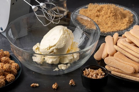 Glass bowl with quark surrounded by bisque and nuts