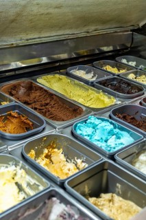 Gelato trays in a chilled display case showing a colorful assortment of italian ice cream