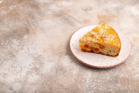 Pie with candied fruit, on brown concrete background, copy space, side view