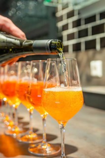 A sparkling drink is poured into aperitif glasses at a modern bar, Cafe Kuh, Deckenpfronn, Germany
