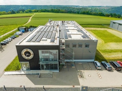 Industrial building with solar system, green fields in sunshine, PV assembly, Perrot company, Calw,