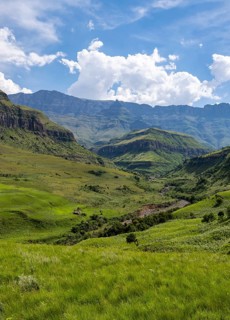 Mountainous landscape of the Cathedral Range mountains and green mountain valley, Drakensberg