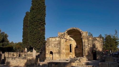 Titus Basilica, Greece, ancient ruin with cypress tree in the background under clear sky, Gortyn,