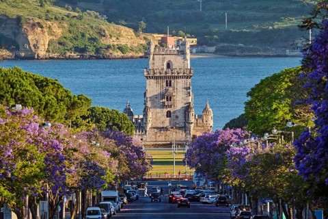 Enjoy a scenic sunset view of Belem Tower overlooking the Tagus River, surrounded by vibrant