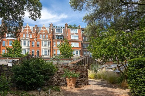 Greenhouses and view of nearby houses, Chelsea Physic Garden, London, England, UK