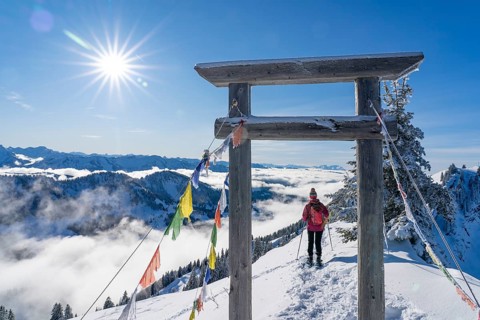 Active senior woman hiking with snowshoes on the Nagelfluh mountain chain ini the Allgaeu Alps near