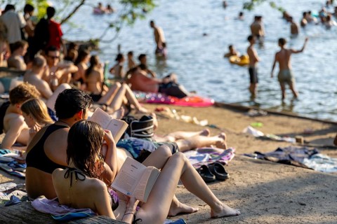 Berlin, Germany -28.6.2026: Two woman read books on the beach of Krummen Lanke, a lake in Berlin,