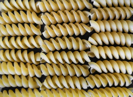 The texture of fusilli pasta on a black background. wallpaper. background. Close-up. Horizontal