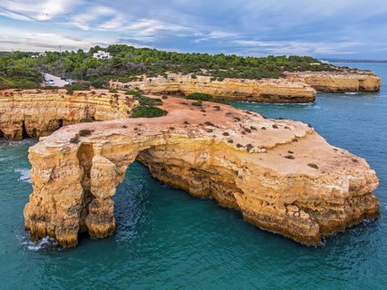 Drone view of Arco de Albandeira and Praia de Albandeira in Algarve, Portugal, with limestone