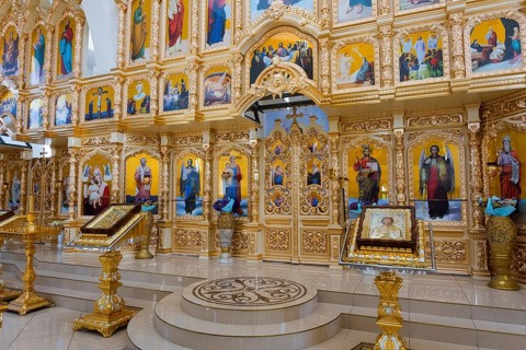 Magnificent icon wall in an Orthodox church with golden decorations and religious paintings,