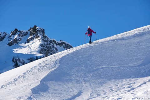 Woman hiking with snow shoes in the Kleinwalsertal, Vorarlberg, Austria