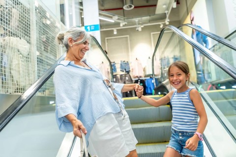 Grandmother and granddaughter holding hands, smiling and enjoying their time together while going