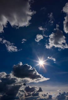 Sun shines between cumulus clouds, dramatic cloudy sky, Austria