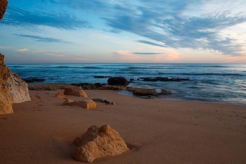 Quiet beach with rocks at sunrise, soft waves and pastel sky, sunset, Praia do Amado, Carrapateira,