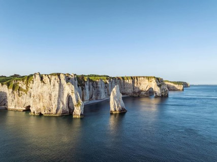 Aerial view of the Porte d'Aval rock formation with the free-standing Aiguille d'Étretat rock pin