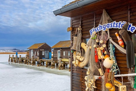 Old fenders, fishing nets and lifebuoys on boathouse in the Gager harbour in winter, Mönchgut