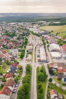 Bird's-eye view of the city, long railway tracks surrounded by buildings and landscape, Hermann
