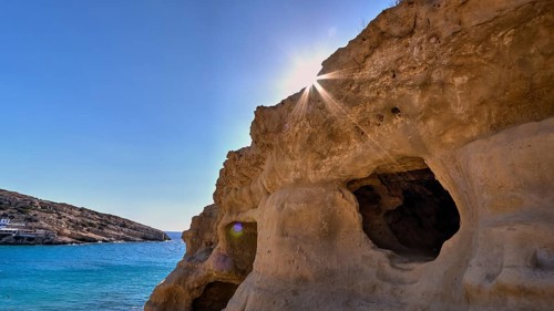 Neolithic caves, former hippie paradise, cave with sunbeams over the sea, natural rock formations,