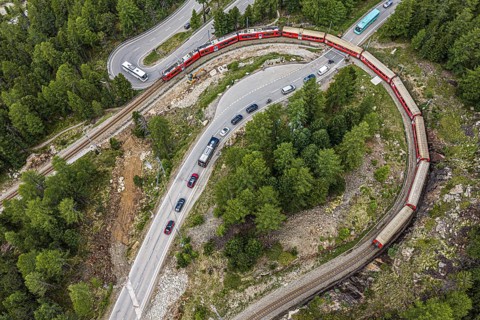 Red train of the Rhaetian railroad line, Bernina Express, 180 degree turn at the Montebello curve,