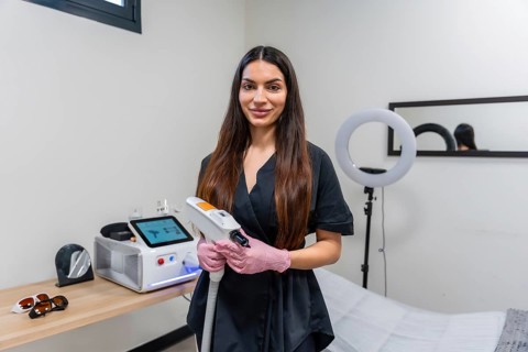 Female professional in a clinic holding a modern laser device, ready for aesthetic treatments like