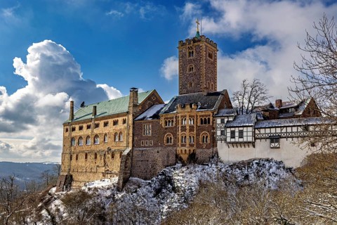 Castle with towers in snow under dramatic sky, medieval architecture, The Wartburg near Eisenach in