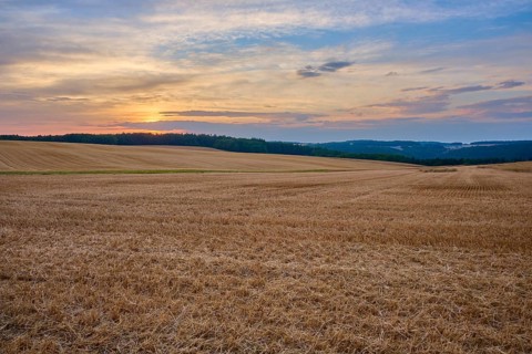 Wide stubble field under a colorful sunset sky with clouds, summer, Neudorf, Amorbach, Odenwald,