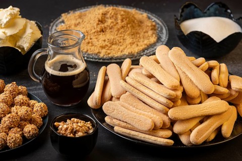 Ingredients for a dessert, such as sponge cake, nuts, sugar, and coffee