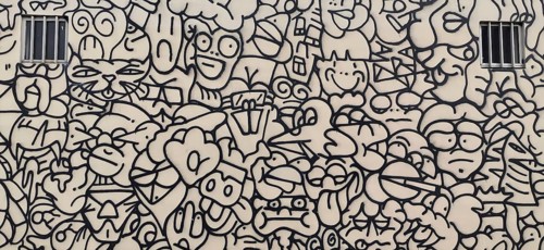 Wall painting of a house façade in black and white with abstract comic faces and shapes, Lisbon,