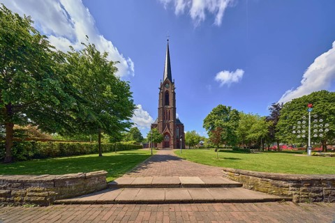 St. Nicholas parish church, church tower, sandstone wall, staircase, green area Bürgerpark, lawn,