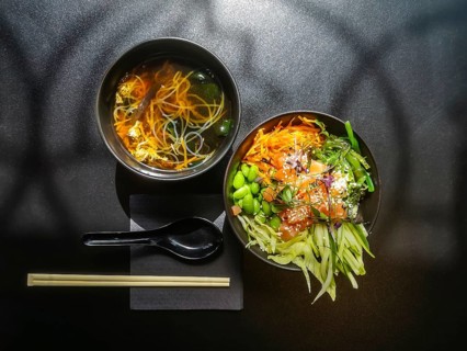 Lunch in Asian style. Shiro miso soup and poke bowl with salmon, cucumbers, green beans, carrots