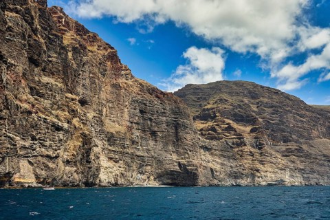 Los Gigantes, steep cliffs under a bright blue sky over a calm sea, whale watching boat tour, whale