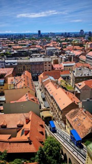 Panoramic view from Lotrscak Tower over the old town of Zagreb with red roofs and a cable car going