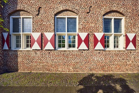 House Wachtendonk, historic brick building, façade with windows, shutters and wall anchors,