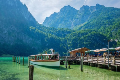 Tourist passenger boat at the Konigsee pier in Bavaria, Germany, with clear lake water and