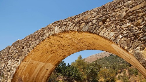 Old stone bridge with arch against natural background, Amari Basin, Amari, Central Crete, Greek