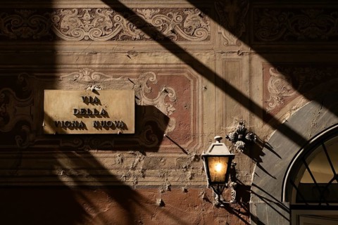 House wall painted with arabesques, street light, shadow, Florence, Tuscany, Italy