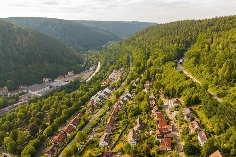 A village in a green valley with houses and tracks, surrounded by forest, Hermann Hesse Railway,