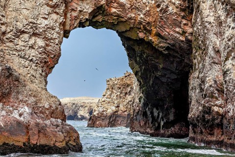 Spectacular rock arch over rough water with views of the sea, The rocky coast of the Ballestas