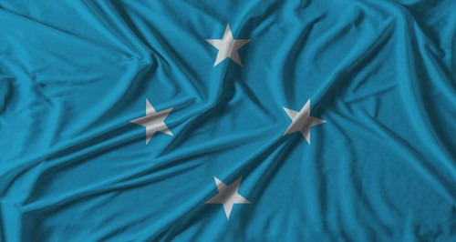 Micronesia flag with fabric texture background. National flag of Micronesia with cloth texture