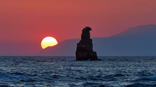Sunset bathes the sky and sea in a calming red light with a rugged rock, sunset, South of the Amari