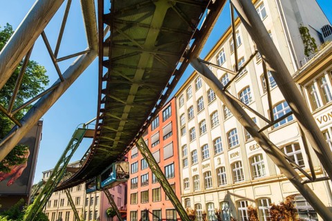 A suspension railway runs between old industrial buildings near the Kluse stop, Wuppertal, Germany