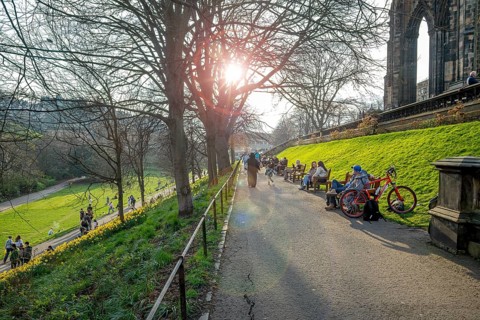 Residents sunning in spring at the Princes Street Gardens, public park in the city centre of