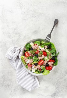 Salad with canned tuna, vegetable salad with quail eggs, lettuce and romaine leaves, red onion,