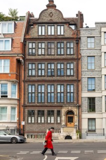 Chelsea pensioner in red uniform walking on street past, 19 Cheyne Place, Royal Hospital Road,