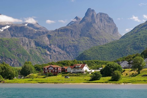 Small waterfront settlement with impressive mountain scenery and blue sky, Romsdalshornet,