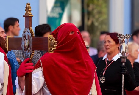 Red-hooded person wearing a cross in the midst of a crowd, Good Friday procession, Easter, UNESCO