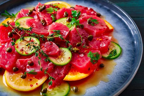 Sicilian tuna crudo, on a plate, wooden background, italian dish, homemade, no people