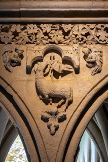 Close-up of an ornate historic stone relief in the cloister of Mont Saint Michel Abbey, depicting