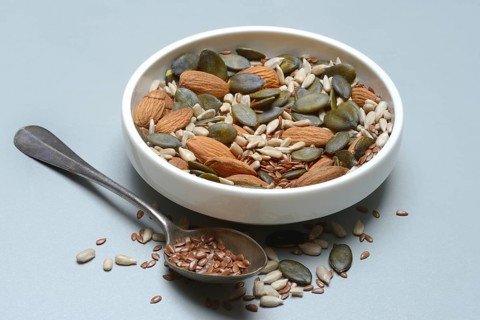 Seeds in bowls, mix of almond seeds, sunflower seeds, linseeds and pumpkin seeds